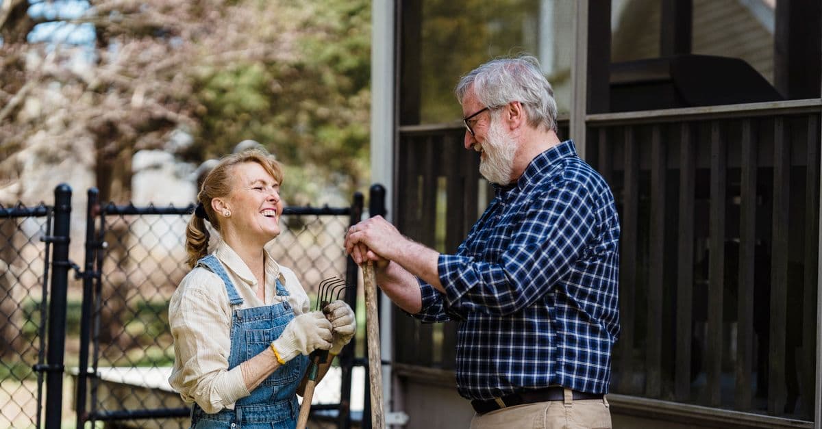 Two people tending a garden together on a bright morning.
